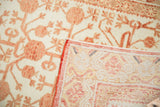 Distressed ivory Khotan runner with faded cinnabar pomegranate motifs and hand-knotted reverse.