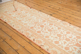 Distressed Khotan rug runner with repeating ivory and pale cinnabar pomegranate motifs.