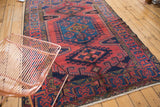 Persian Veece rug corner, geometric navy blue border with black cherry wine red field and fringe.