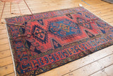 Vintage Veece rug's detailed navy geometric border and black cherry red field.