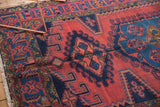 Close-up of vintage Veece rug's geometric medallion design in rich black cherry and navy blue.