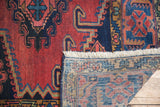 Fringe, low red pile, and hand-knotted blue, blush reverse of a vintage Veece rug.