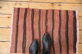 Vintage Turkish Kilim rug's fringed edge, with pale red and dark brown banded pattern.