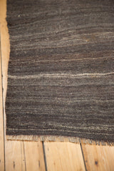 Hand woven vintage Turkish Kilim rug showing neutral charcoal, platinum tones and fringe.