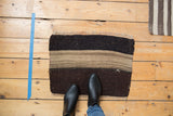 Top left corner of a Turkish Kilim, showing charcoal and neutral bands with subtle abrashes.