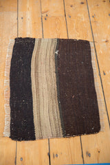 Corner of a Vintage Turkish Kilim rug with neutral striped bands and soft fringe.