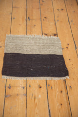Contrasting charcoal and antique ivory fringe on a hand woven Kilim.