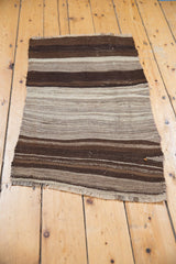 Hand woven vintage Turkish Kilim rug with striating brown-gray bands, natural fringe, and oblique weave.