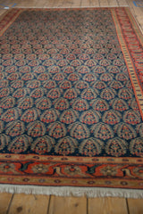 Vintage Malayer rug's navy blue field, repeating tree-of-life boteh motifs, and red-orange border.