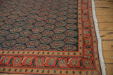 Vintage Malayer carpet with repeating paisley boteh motifs and an ornate orange-red border.
