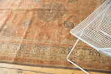 Ornate floral border of the distressed Turkish Kaisery carpet in dusty rose, slate grey, and ivory.