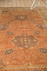 Distressed pile texture of a vintage Kaisery rug with faded dusty rose floral motifs.