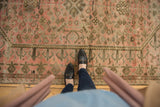 Distressed vintage Oushak rug with muted blush, silver, and charcoal geometric border designs.