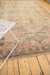 Blush and dusty charcoal motifs with distressed even wear on a vintage Oushak carpet.