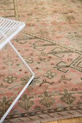 Distressed texture and time-softened blush and charcoal patterns on a vintage Oushak rug.