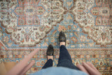Distressed vintage Mahal carpet, faded blue, terracotta, and green geometric vinery.
