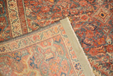 Folded vintage Hamadan rug corner shows worn red pile and tightly woven ivory foundation.