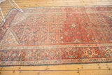 Vintage Hamadan carpet: faded terracotta, royal blue turtle border and Herati field, abrashes visible.