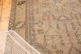 Vintage distressed Oushak rug with geometric potted plant motifs, beige and dark brown.