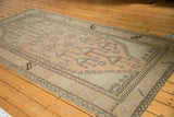 Distressed Oushak runner, faded geometric potted plants, and visible knot head wear.