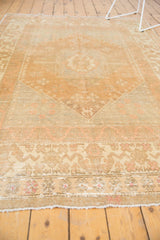 Vintage Oushak carpet's secured end fringe, showing pale blush floral cross-section minor border.