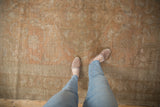 Low pile texture on a distressed vintage Oushak carpet with faded apricot and sand hues.