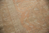 Decorative distressed low pile texture of a vintage Oushak carpet with muted apricot and antique ivory tones.