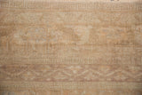 Vintage distressed Oushak rug showcasing its low pile and soft, faded apricot and sand tones.