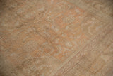Faded apricot tones and low pile texture of a distressed vintage Oushak carpet.