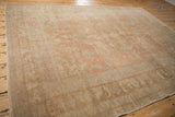 Surface detail of distressed Oushak carpet, soft low pile in apricot and pale sand hues.