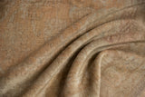 Textured folds of distressed vintage Oushak rug pile with soft sand and apricot tones.