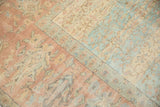 Faded terracotta and powder blue fields with delicate scrolling vinery on a distressed Oushak.