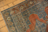 Distressed vintage Senneh rug showing muted terracotta and blue Herati motifs with foundation wear.