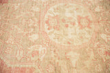 Distressed pile texture of a vintage Oushak rug, revealing pale cinnabar and ivory pattern.