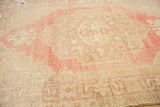 Worn pale cinnabar red and ivory spandrel detail on a vintage Turkish Oushak rug.