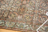 Distressed texture of vintage Mahal carpet with floral palmette motif and terracotta border.