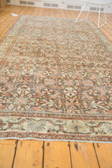 Fully secured ends and patterned borders of the distressed Mahal carpet in ivory and terracotta.