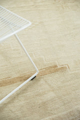 Distressed Oushak carpet's low pile showing subtle geometric pattern and ivory to brown abrash.