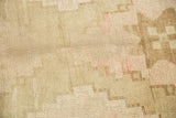 Distressed vintage Oushak rug detail with blossomed beige, brown, and blush pile.