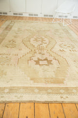 Hand-knotted vintage Oushak rug's lower section, showing distressed low pile and subtle beige-pink hues.