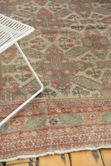 Distressed Kayseri carpet border: geometric patterns in terra cotta, celadon, ivory, tattered fringe.