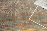 Distressed vintage Turkish Kayseri carpet detail with geometric floral field, muted border, and visible wear.