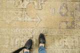 Pale beige distressed vintage Oushak rug, showing even wear with faint foundation.