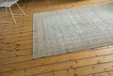 Distressed Turkish Oushak rug in soft slate blue and ivory, with muted floral lattice pattern.