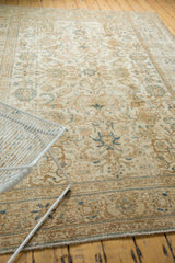 Faded blue floral border and visible knot wear on distressed vintage Sparta carpet corner.