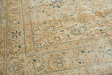 Distressed vintage Sparta rug corner, highlighting ivory, pale gold, and blue floral palmettes.