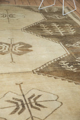 Distressed Oushak rug with primitive germinating plant motifs in beige and charcoal brown.