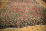 Vintage distressed Arak carpet detail: mostly even wear on cinnabar field with traditional floral patterns.