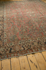 Distressed corner of vintage Arak carpet, dark charcoal border, foundation showing through.