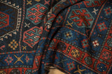 Vintage Kurdish rug with geometric guls in blue, red, gold on low, textured pile.